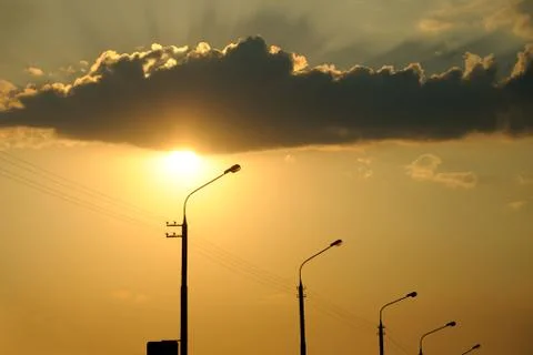 Sunset. interesting illumination of a cloud behind Stock Photos