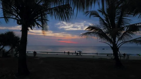 Sunset at Karon Beach, dusk and nightfall, dark clouds, red sky, coconut trees Stock Footage 246065405