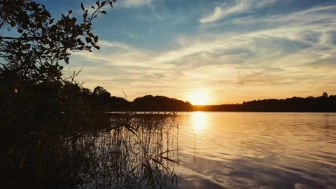 Sunset Lake Beneath Wispy Clouds With Golden Nature Reflection Stock Footage 342006783