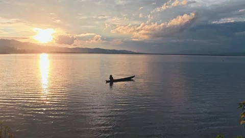 Sunset on the lake with a boat in the foreground Stock Footage 302616975
