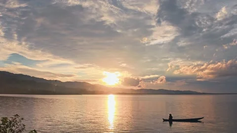 Sunset on the lake with a boat in the foreground Stock Footage 302617637