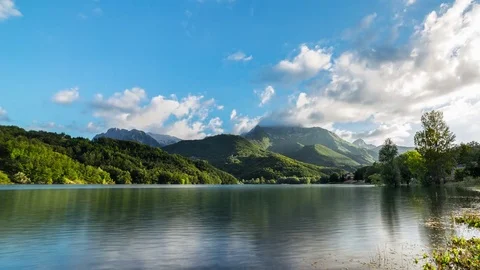 Sunset on Lake with clouds and mountains background. Water reflections Timelapse Stock Footage 77982250