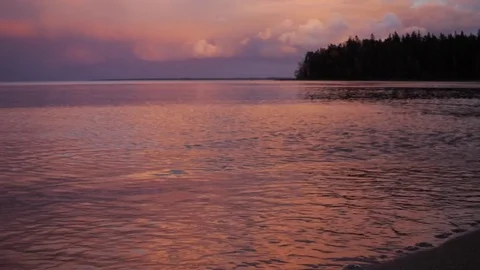 Sunset on the lake. Evening in Karelia. Waves on the sand. Stock Footage 79590823
