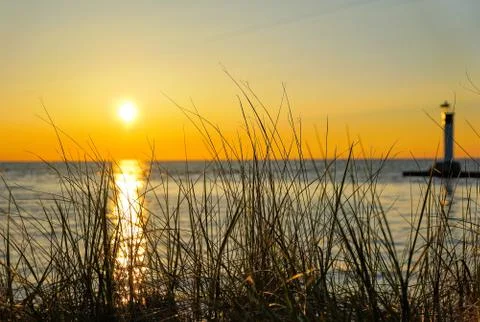 Sunset on lake with grass dune Stock Photos