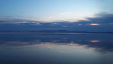 Sunset on the lake with a mirror image of the sky on the surface of the water. Vídeo Stock 274206811
