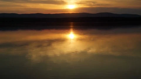 Sunset on the lake with a mirror image of the sky on the water. Love of nature. Stock Footage 277559487