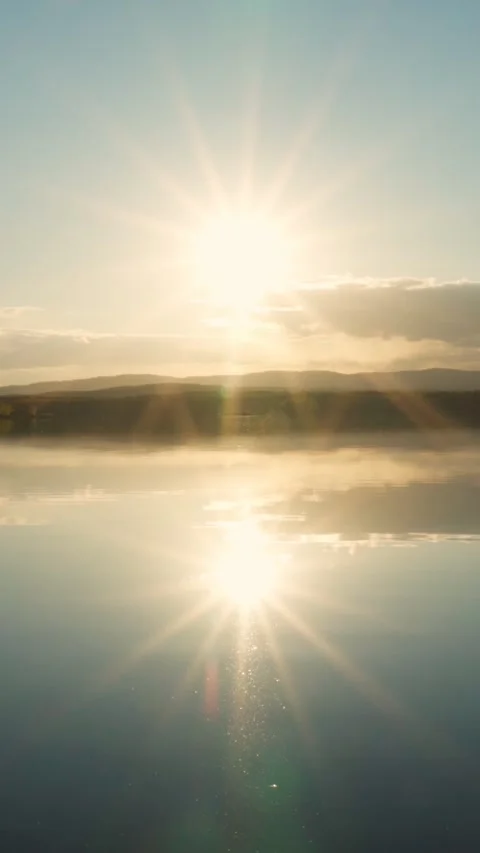 Sunset on the lake with a mirror image of the sun and sky on the water. Video stock 276876977