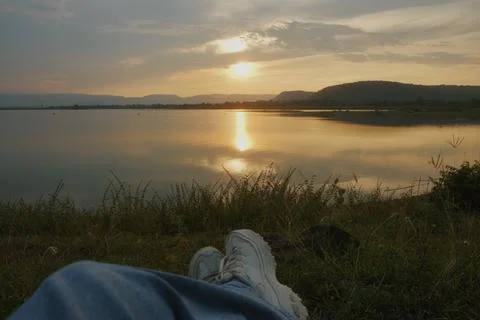 Sunset lake reflection shoreline grass shoe evoke peaceful outdoor moment b.. Stock Photos