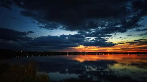 Sunset on the lake, sunlight and clouds Stock Photos