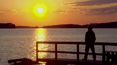 Sunset on the lake. Sunset reflected in water and silhouette of man Vidéo 67532663