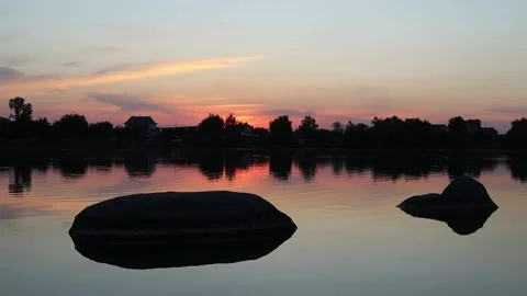 Sunset, lake, two large round stones in the water, small waves on the water Stock Footage 207858878