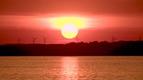 Sunset on a lake with wind turbines Stock Footage 155822244