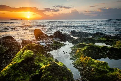 Sunset landscape on the beach rocks in foreground Foto stock