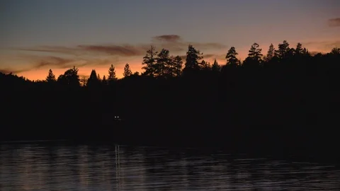 Sunset landscape of lake, pine forest and road. Beautiful establishing shot Stock Footage 114625687