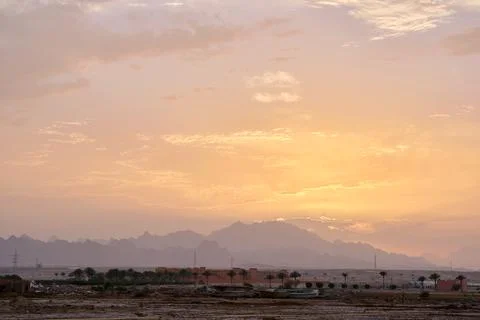 Sunset landscape with remote hotel complex against dark mountain peaks in Stock Photos