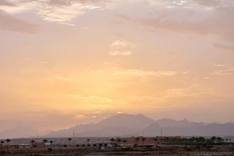 Sunset landscape with remote hotel complex against dark mountain peaks in egy Stock Photos
