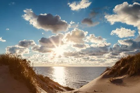 Sunset landscape with sun,clouds and dunes Stock Photos