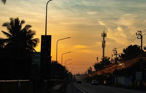 Sunset light behind the coconut trees and the road. Stock Photos