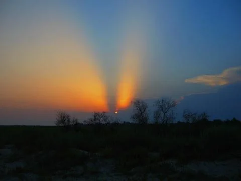 Sunset Light Breaking Through Storm Clouds Over the Coastline Stock Photos