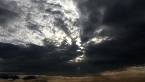 Sunset light breaks through dark storm clouds after rain - Atmospheric Renewal Stock Footage 339339850