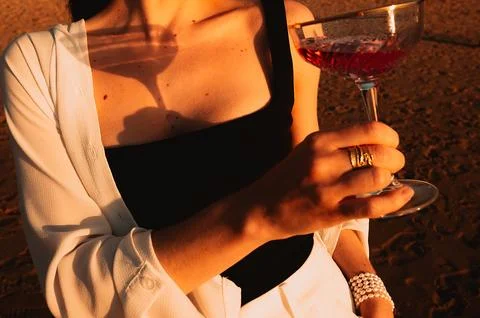 Sunset light casts a shadow of a glass on a person's skin during a summer gat Stock Photos