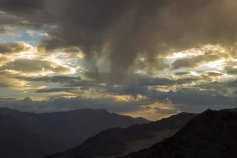Sunset light on the clouds in the mountain valley Stock Photos