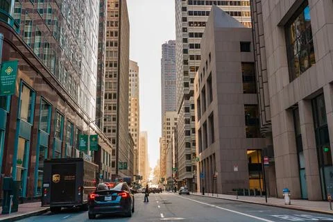 Sunset light filters through a corridor of high-rise buildings in downtown .. Stock Photos