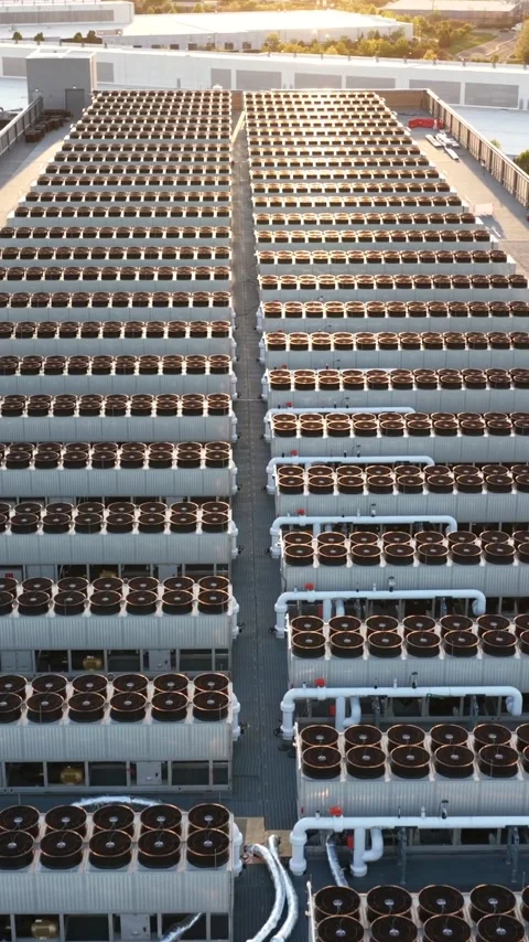 Sunset light floods rows of rooftop condenser fans at a hyperscale data center Stock Footage 345728009