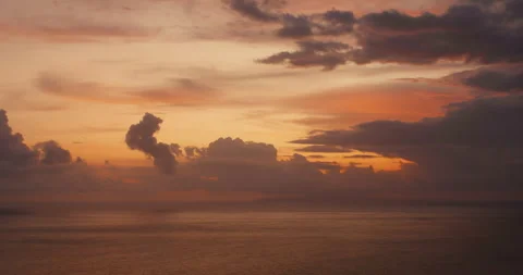 Sunset light glows through heavy clouds above the Indian Ocean at twilight Stock Footage 341294250