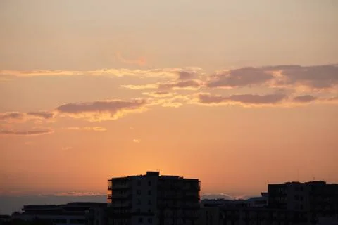 Sunset light on a modern multi-storey building. the sky with clouds of differ Stock Photos