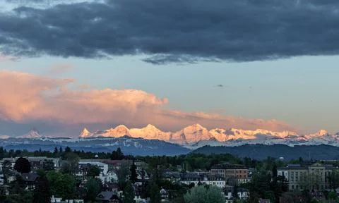 Sunset light on mountain range eiger moench and jungfrau above bern suburbs Foto stock