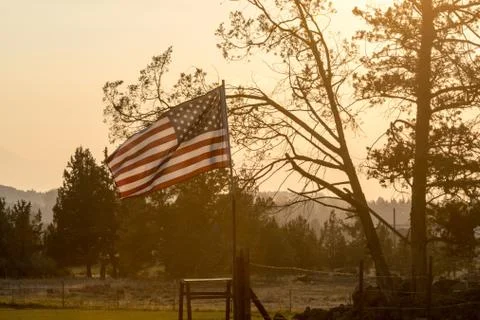 Sunset light passes through a waving U.S. flag near Terrebonne Stock Photos
