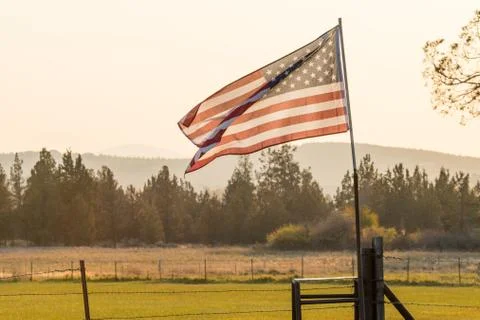 Sunset light passes through a waving U.S. flag near Terrebonne Stock Photos