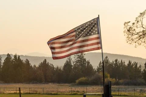 Sunset light passes through a waving U.S. flag near Terrebonne Stock Photos