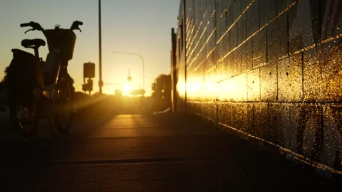 Sunset light reflected on a wall with traffic in background and bike 6K Stock Footage 310589049