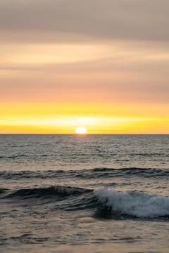 Sunset light reflections on ocean surface with vivid orange tones Stock Photos
