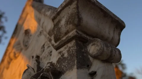 Sunset light on sandstone headstone and cross in cemetary, slow motion reveal Stock Footage 92103100
