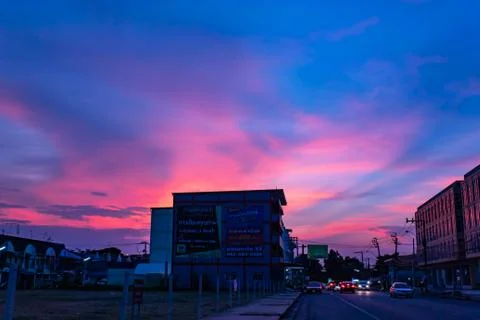 Sunset light in the sky behind the building and the road. Stock Photos