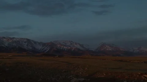 Sunset light on snow mountains with dramatic sky Видео 333953061