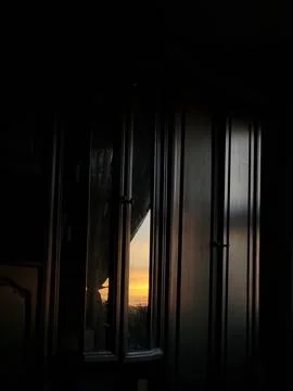 Sunset light through dark room window Stock Photos