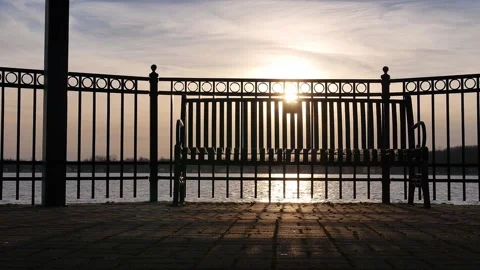 Sunset Light Through Fence and Bench on Lake Stock Footage 236417886