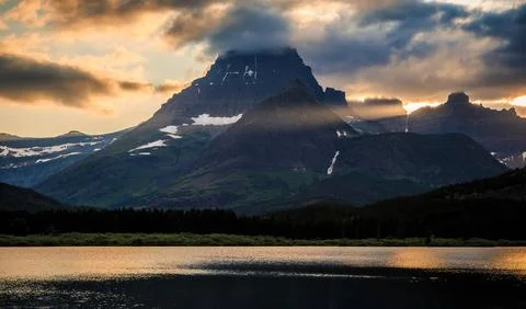 Sunset Light Through the Mountains of Glacier above Swiftcurrent Lake, Many Foto stock
