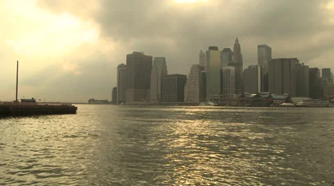Sunset light washes over Manhattan waterline with storm clouds gathering Stock Footage 39605294