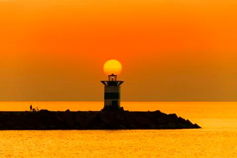 Sunset on the lighthouse of Scheveningen harbor at the summer hottest day eve Фото