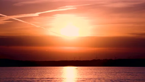 Sunset lighting up the sky orange on a lake Stock Footage 155822220
