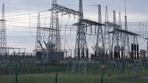 Sunset-lit clouds provide a dramatic backdrop for a transformer station cap.. Stock Footage 259049165