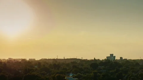 Sunset in the little city. The sun sets over the horizon, the lights of the Stock Footage 77202972