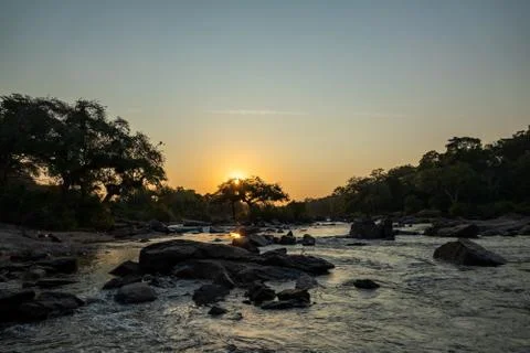 Sunset in Malawi river with trees, rocks and text space Stock Photos