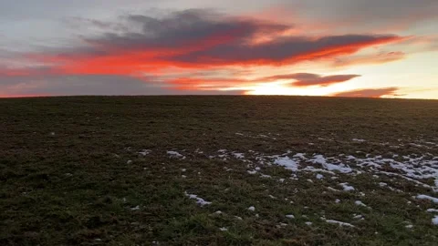 Sunset at the meadow with grass covered with melting snow Stock Footage 233258171