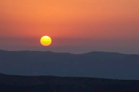 Sunset on the mountain, sun setting behind the mountain. Stock Photos